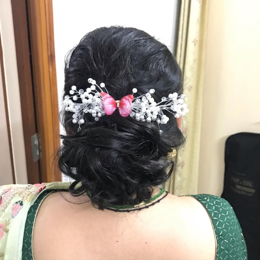 messy high bun for round faced girls with chiffon sarees